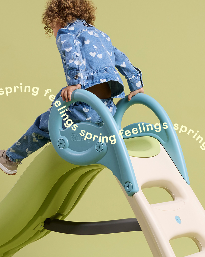 Barn klatrer opp på en rutsjebane med teksten 'spring feelings spring'.