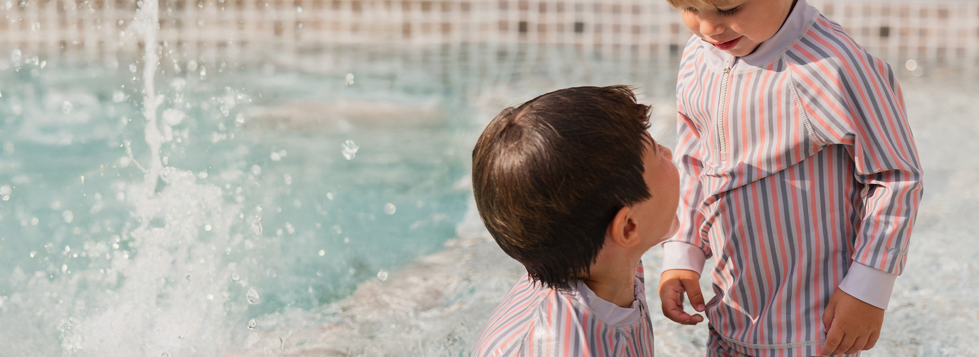 En kvinne smiler til en gutt som holder en blomst, med teksten 'Kenza X Viking'.